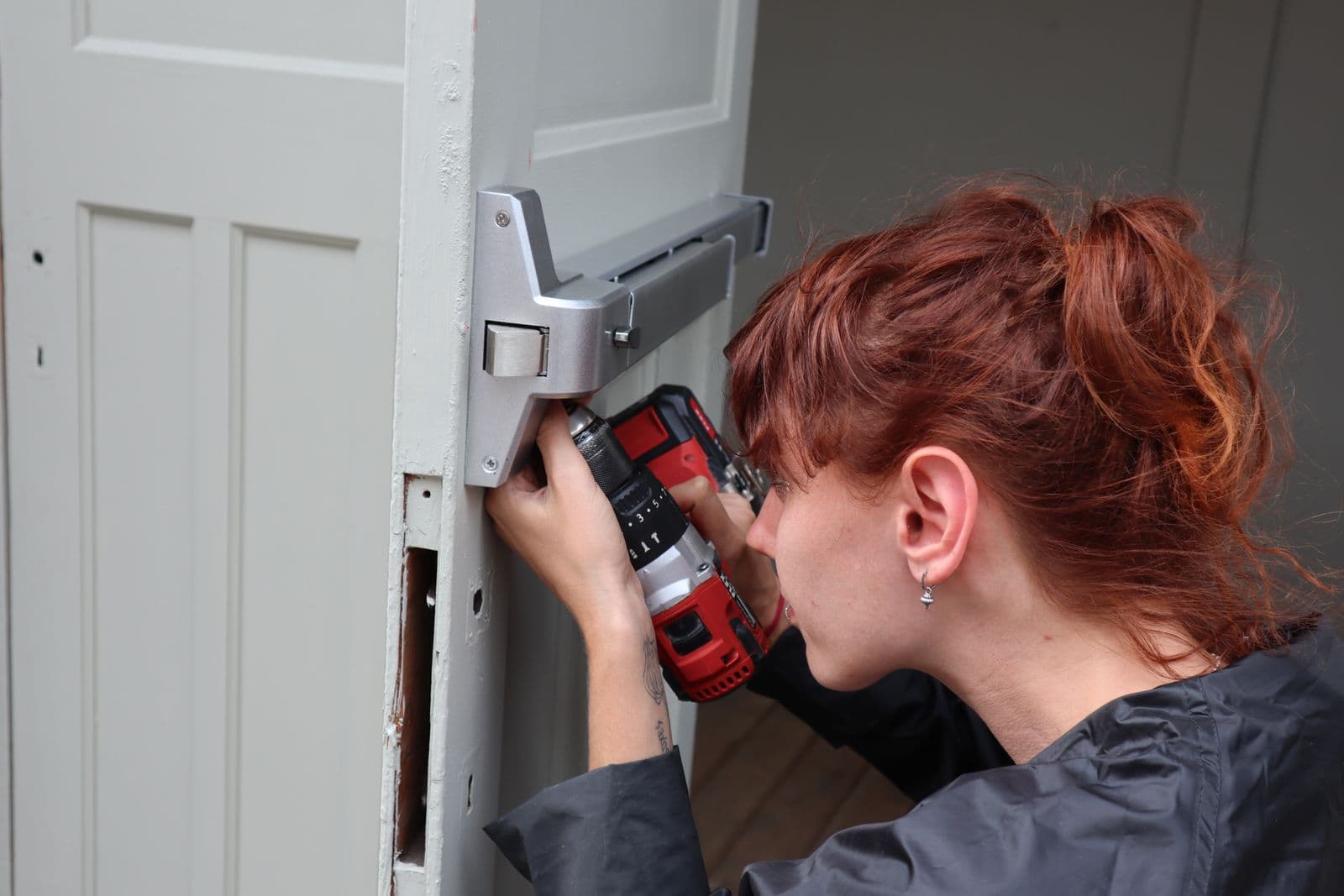 Pro installing new door hardware with a cordless drill