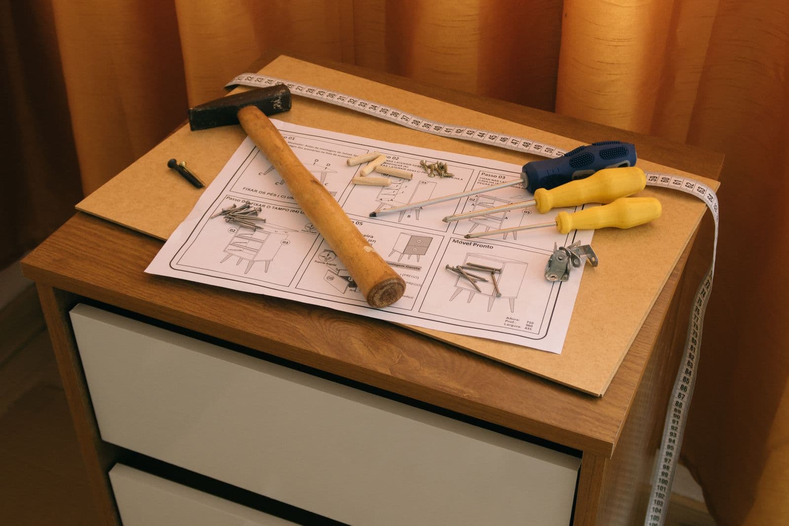 Flat-pack cabinet parts laid out with the instruction sheet and tools